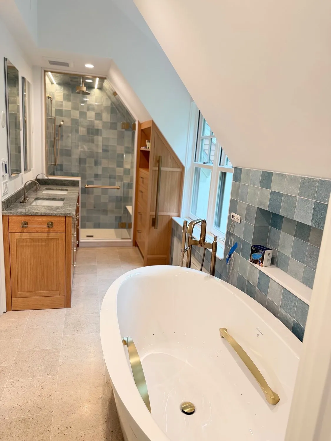 A bathroom with a freestanding tub, tiled wall and a frosted glass door
