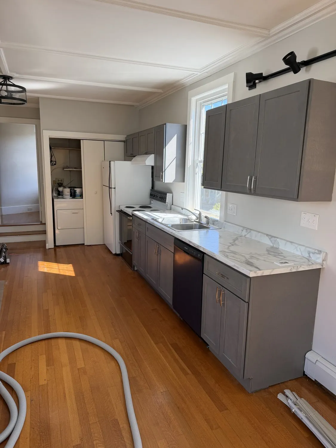 A Danvers kitchen counter run with gray cabinets and a marble countertop
