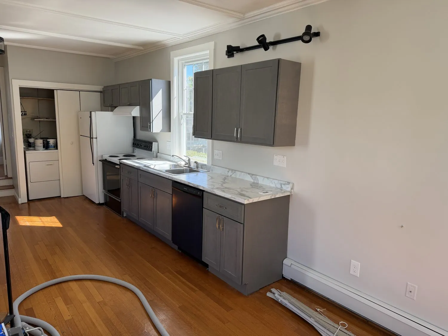 A wide view of a Danvers kitchen with gray cabinets and pale walls