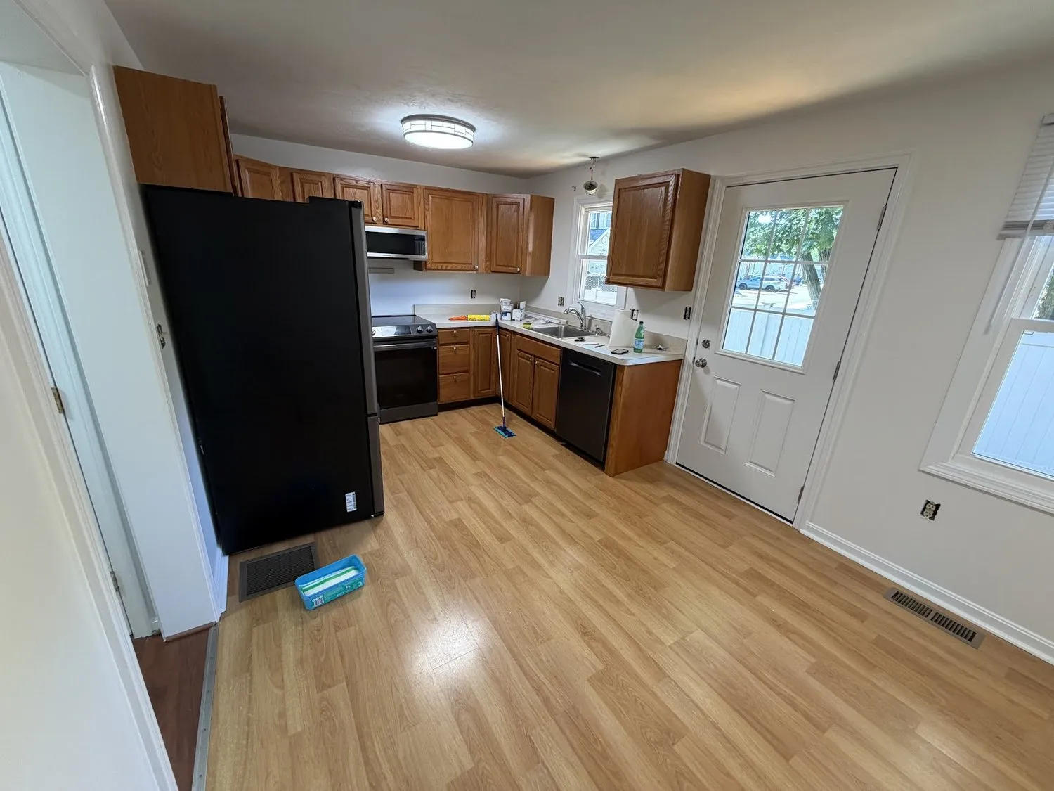 A kitchen with wood-stained cabinets and pale walls