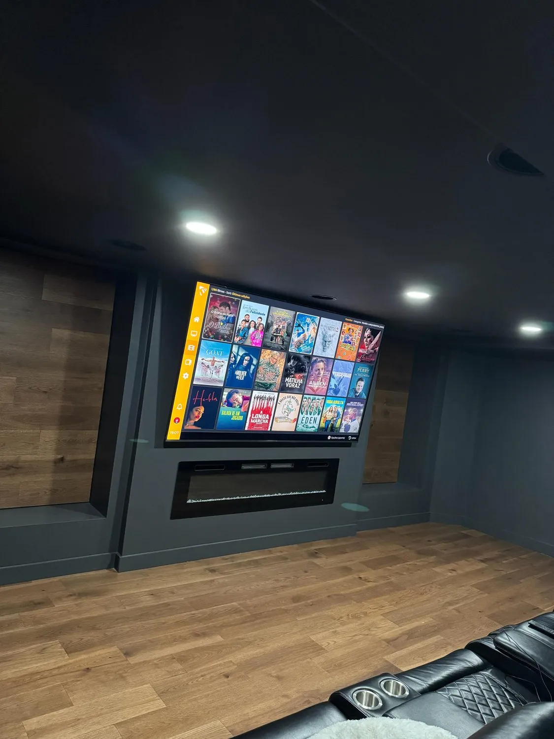 The screen wall of a Leominster home cinema, painted charcoal with a wood surround