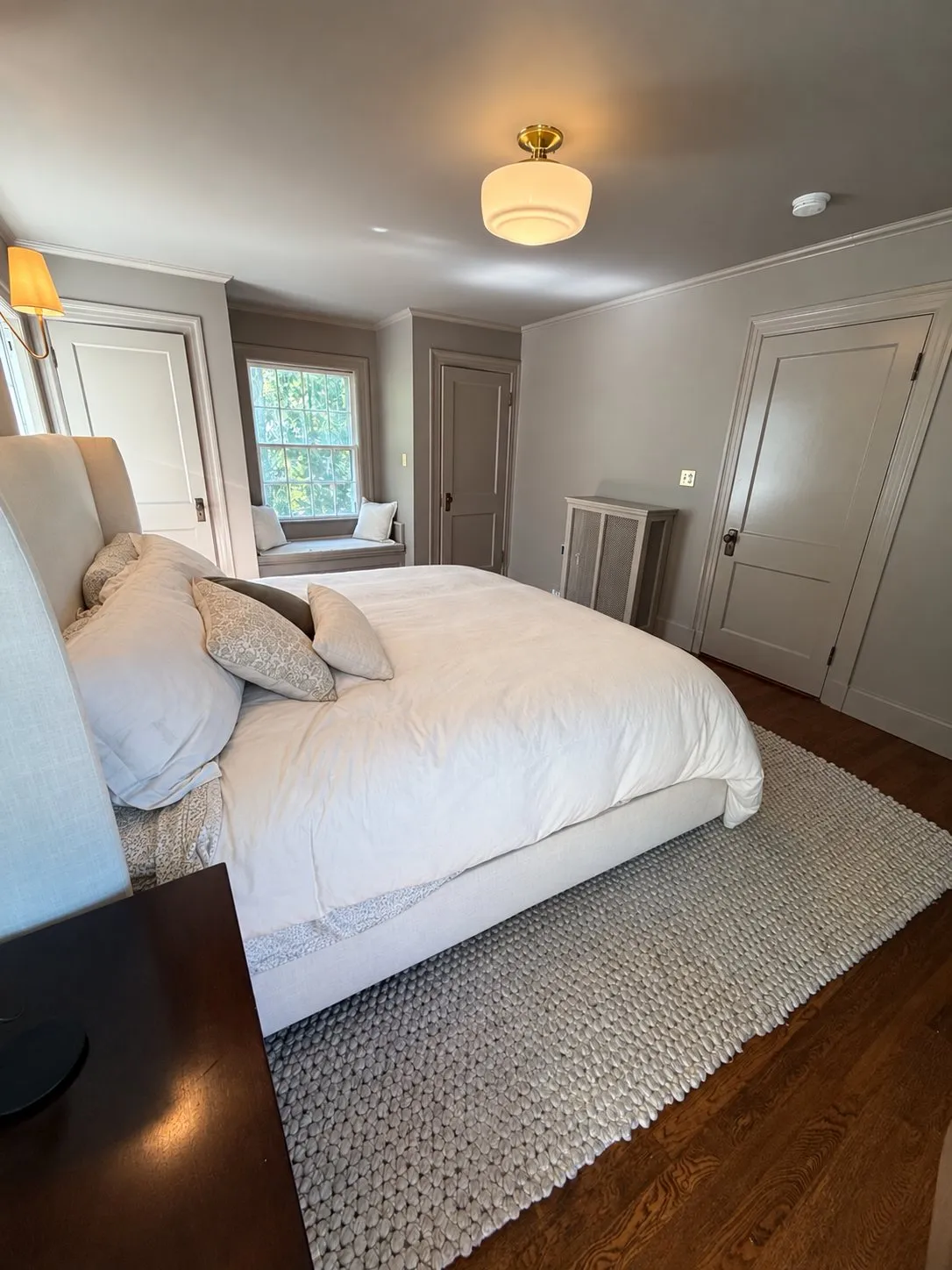 A Newton bedroom in warm cream with white trim and a paneled door