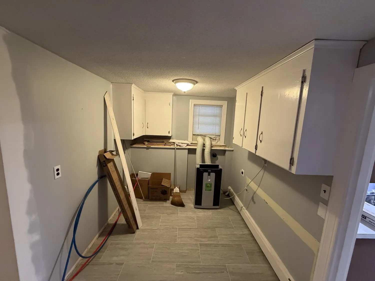 A Norwood galley kitchen painted white, mid-job with materials on the floor