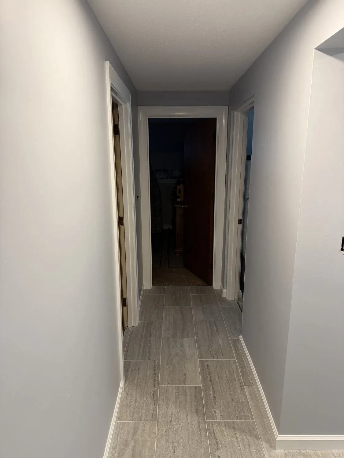A long Norwood hallway painted pale gray, running past several doorways
