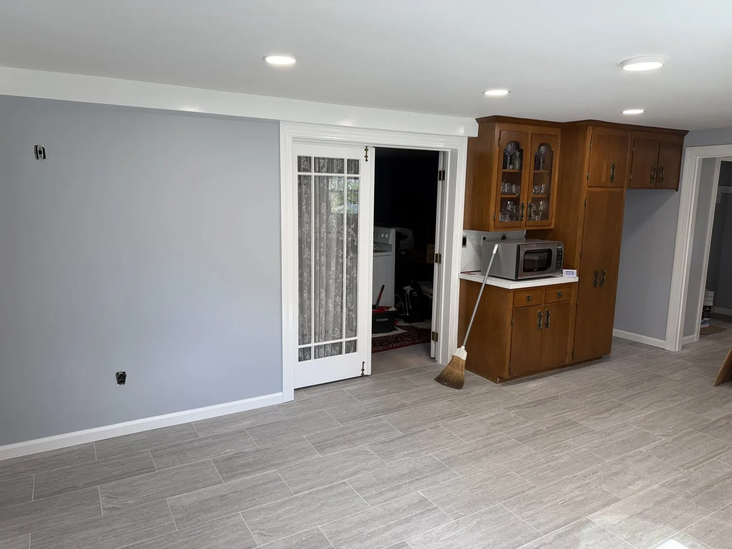 A Norwood kitchen with blue-gray walls, white trim and dark wood cabinets