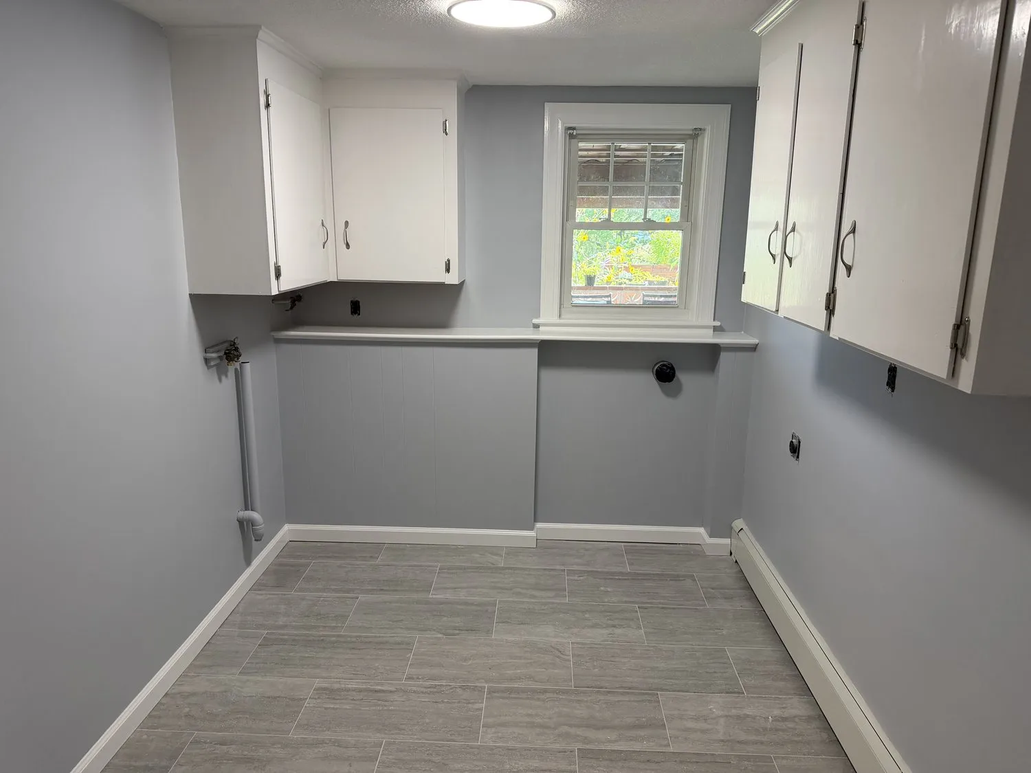 A Norwood kitchen corner with white upper cabinets and pale gray walls