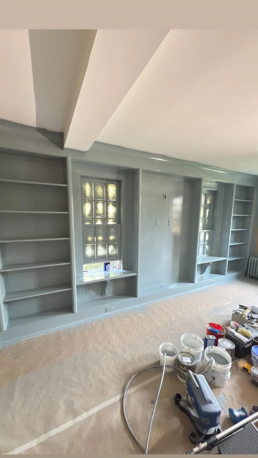 A room mid-job with walls freshly coated and equipment on protective floor covering