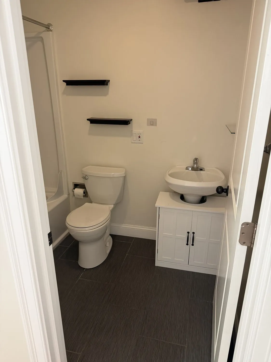 A second Roxbury bathroom in white with a dark floor and a fitted vanity
