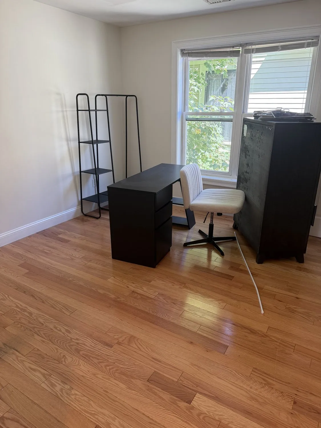 A Roxbury home office painted white with a desk and shelving unit